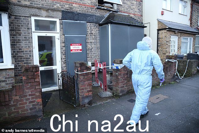 周日拍摄的一名法医官员走过桑德斯特德路上的房子,周五晚上,那里爆发了一场大火