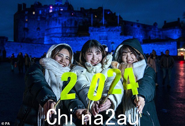 爱丁堡:来自日本的大学生在爱丁堡城堡前举着写着“2024”的标语牌摆姿势