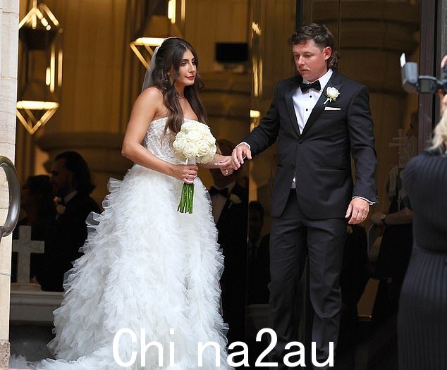 Naoum 身着白色无肩带薄纱和蕾丝花边礼服,搭配及地面纱抢尽风头