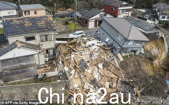 TOPSHOT - 这张航拍照片显示了 2024 年 1 月 2 日石川县轮岛市一条街道上受损和被摧毁的房屋，即石川县能登地区发生 7.5 级大地震的第二天。 1 月 2 日，日本救援人员与时间和强烈余震奋力寻找元旦发生的大地震的幸存者，这场地震造成至少 6 人死亡，并留下了满目疮痍的痕迹。 （摄影：Fred MERY/法新社）（摄影：FRED MERY/法新社，盖蒂图片社）