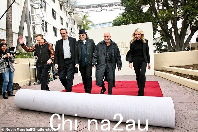 当他们帮助为活动铺地毯时,该小组露出了灿烂的笑容