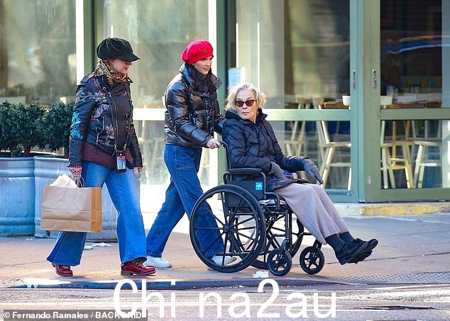 Lange,74 岁,坐在轮椅上,被一位戴着红色贝雷帽的女士推着