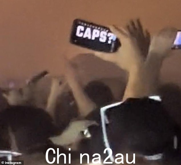 社交媒体上发布的音乐节视频片段显示,一个人举着手机,上面写着“Caps?”写在屏幕上(如图)