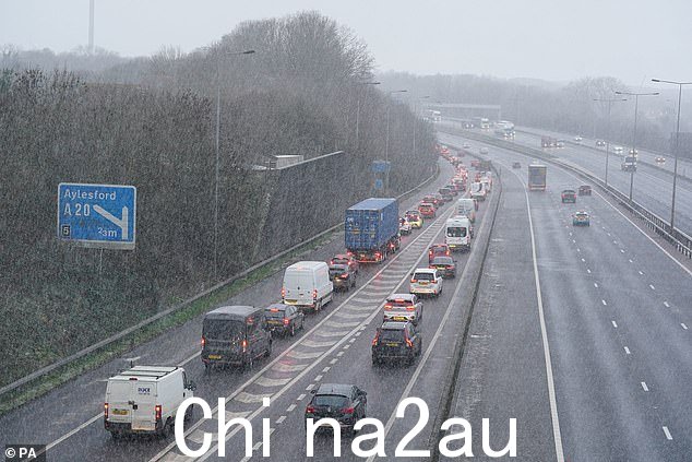 今天,车辆在肯特郡梅德斯通附近的 M20 高速公路上驶过阵雪