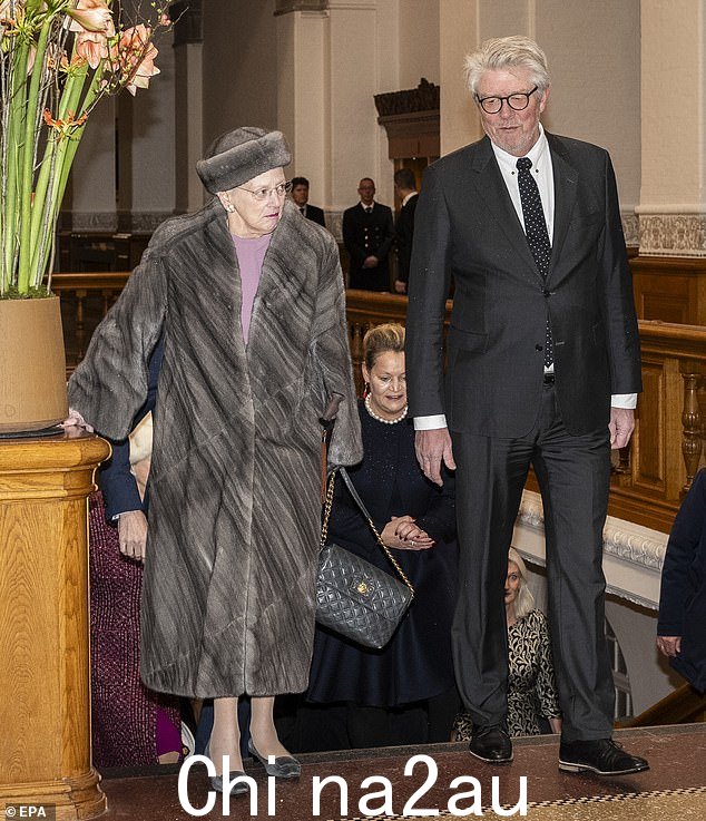 Margrethe 以古怪的时尚感而闻名,她在议会中选择了一件毛皮大衣。图为与丹麦政治家 Karsten Hønge 并肩行走