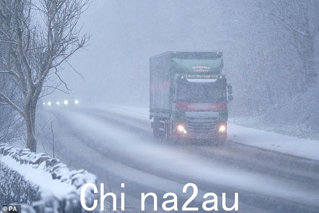 CUMBRIA:一名卡车司机沿着英格兰西北部集镇凯瑟克的雪路行驶