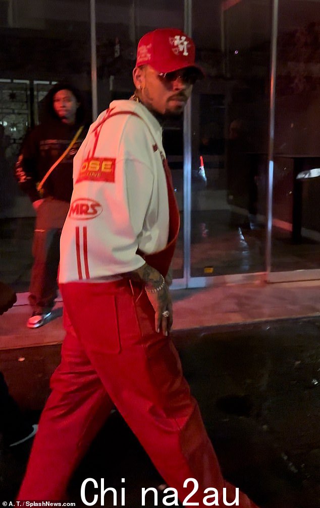 Chris 穿着红色工装裤,搭配棒球帽、运动鞋和运动衫,休闲造型