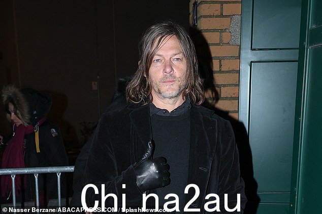 场外,诺曼戴着黑色皮手套,竖起大拇指,与巴黎寒冷的天气作斗争