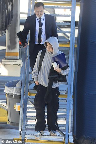 在他身后,另一个人也从台阶上走下来,同时拎着 Chalamet 的吉他盒伸出援助之手