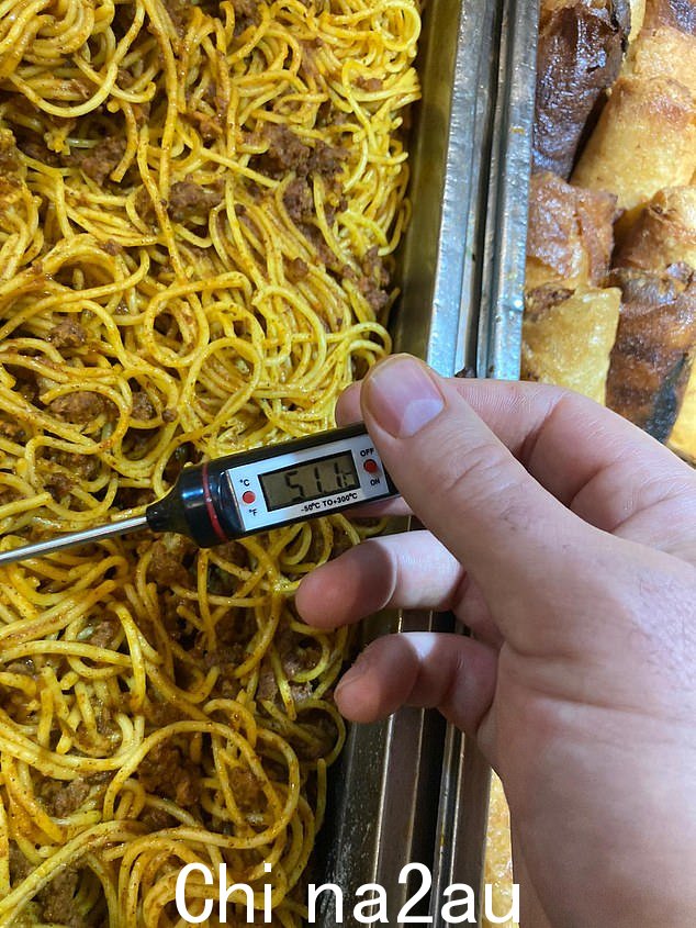 一个人在酒店用温度计测量一批面条的温度。在英国,标准做法是自助餐温度为 63C,并保存两个小时