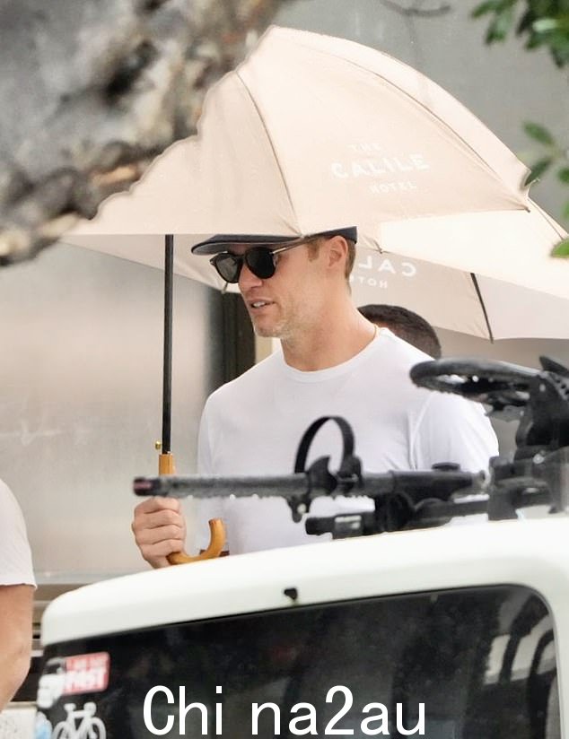 他带着一把印有布里斯班时尚卡利尔酒店标志的雨伞,表明他在昆士兰期间可能会住在那里