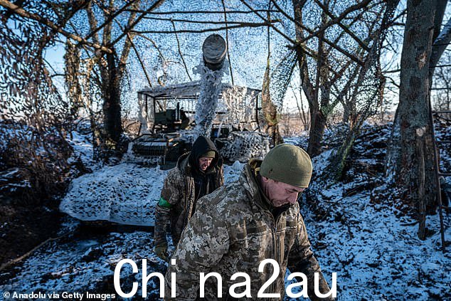 乌克兰士兵在前往巴赫穆特方向前线之前从坦克上取下伪装网
