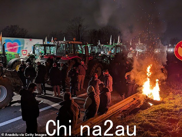 农民们在巴黎南部的堵塞物旁边露营