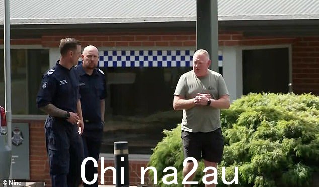 迈克尔·墨菲(与警察合影)周二打破了对失踪妻子的沉默