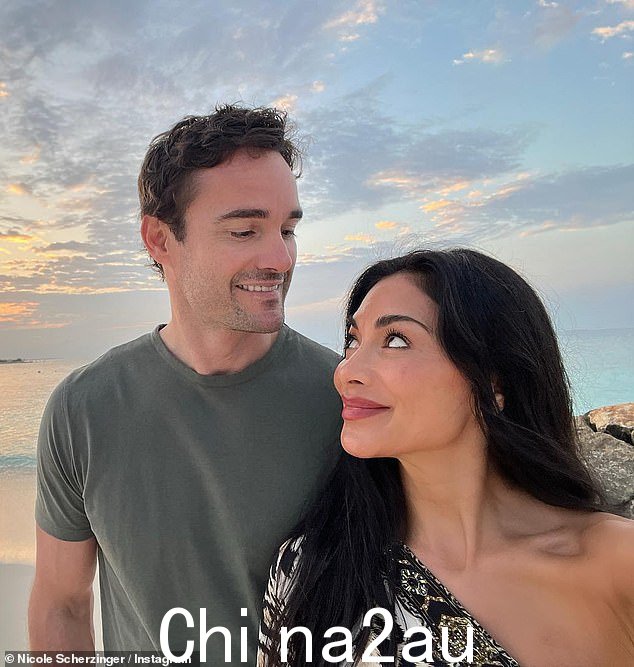 在另一张照片中,这对夫妇在风景如画的海洋日落前的海滩上摆出自拍姿势,互相凝视对方的眼睛,笑容满面