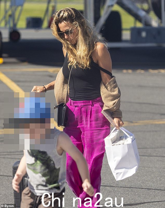 拦截者女演员以黑色运动鞋、一副别致的名牌太阳镜和一个小巧的手提包完成了她的服装