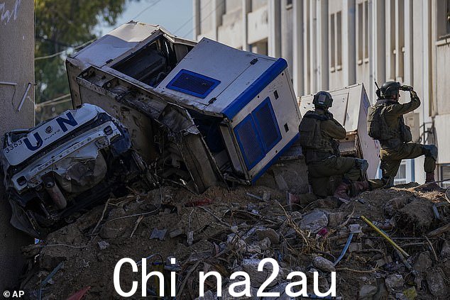 2024 年 2 月 8 日,以色列士兵在联合国近东救济工程处院落的建筑废墟上摇摇欲坠地停泊在破碎的联合国车辆旁边,军方在那里发现了联合国机构主要总部的隧道,军方称哈马斯曾利用这些隧道进行攻击其部队在加沙进行地面行动时