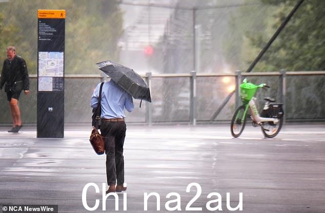 与此同时,周二墨尔本部分地区遭受暴雨袭击(如图:通勤者避雨)