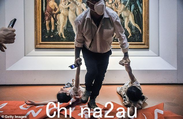 图:2022 年 7 月,一名保安将抗议者拖离画作