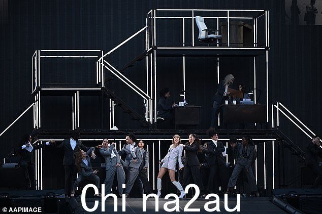 她首先穿着一件灰色西装外套出现在舞台上,然后在与伴舞的序列中展示了下面华丽的服装