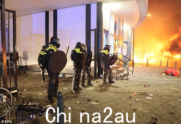 身着防暴装备的警察站在歌剧院大楼前,保护其免受进一步损坏