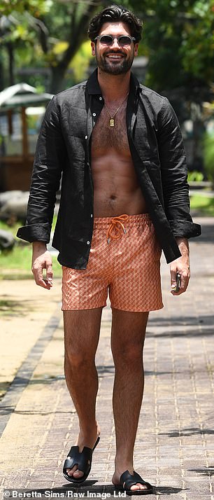 后来他换了整套衣服,穿了一件敞开的黑色长袖衬衫和一条橙色短裤