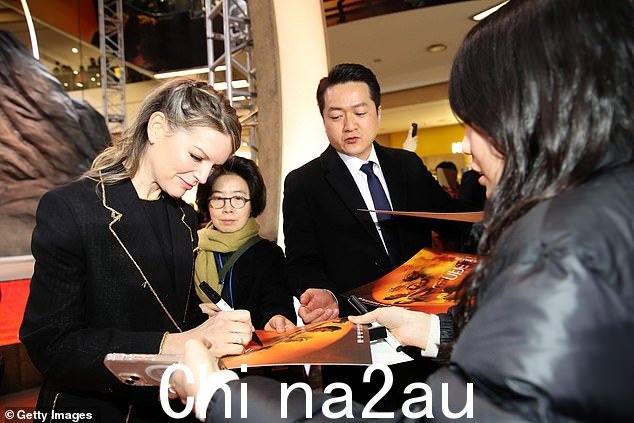Tanya 身穿黑色长裙,金色螺纹下摆,外搭一件相配的外套,塑造别致的身材
