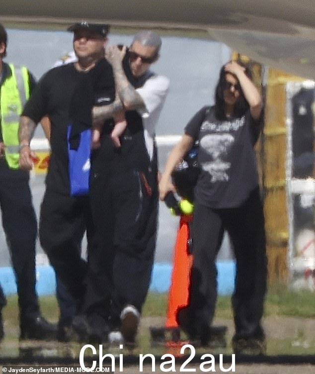 Barker 穿着简单的白色 T 恤,搭配黑色裤子和清爽的白色运动鞋,散发出悠闲的氛围