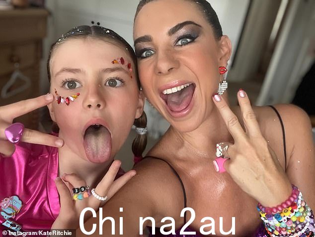 广播明星凯特·里奇 (Kate Ritchie) 还发布了一张自己和九岁女儿梅 (Mae) 的照片,在斯威夫特的表演前,她们化着令人瞠目结舌的妆容,佩戴着珠宝。