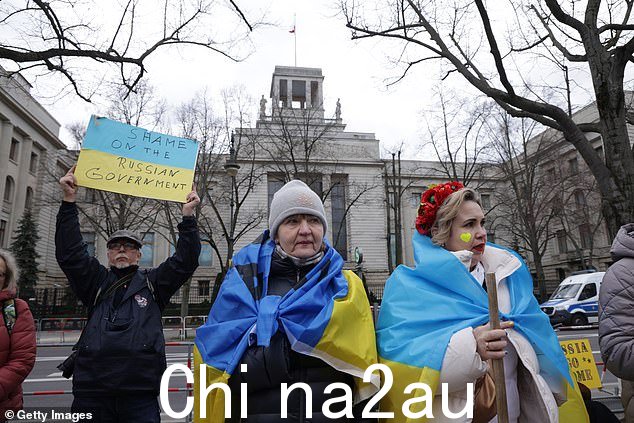 披着乌克兰国旗的妇女在柏林俄罗斯大使馆前抗议,以表达对乌克兰的声援