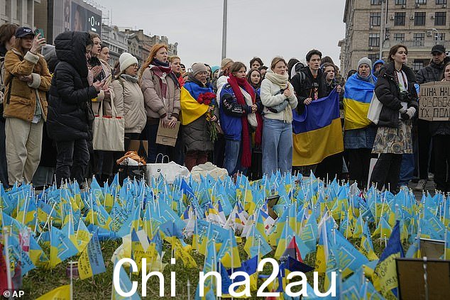 今天早上,人们站在乌克兰基辅市中心迈丹广场附近的战争期间阵亡者纪念碑前