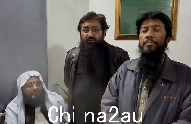 在第二个视频中,该女子被拘留,两侧是警察和伊斯兰神职人员,他们确认她的衣服上没有印有古兰经经文