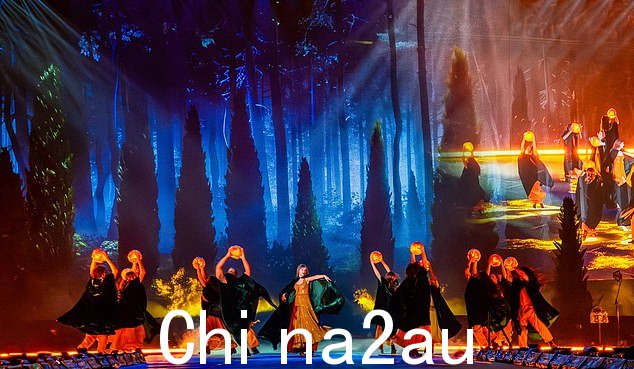 在 Eras 巡演的“evermore”部分,泰勒和伴舞者围着灯笼跳舞时穿着斗篷