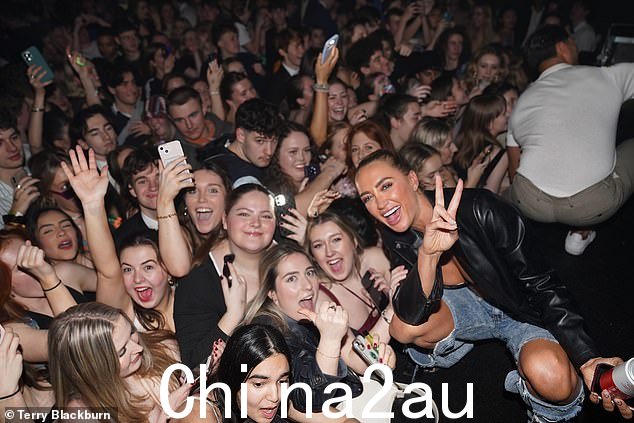 格鲁吉亚举起她在夜总会与粉丝合影时举起和平标志