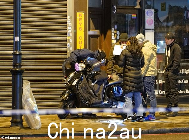 今晚可以看到一群人调查现场并检查轻便摩托车