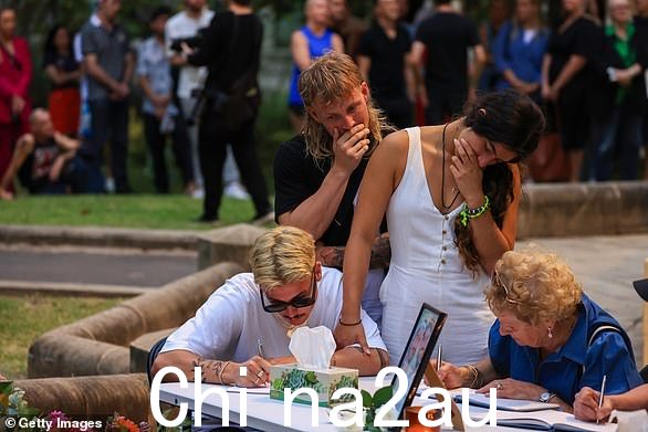 人们在悉尼格林公园的公众守夜活动中在狂欢节庆祝活动前夕签署哀悼书,以纪念杰西·贝尔德和卢克·戴维斯