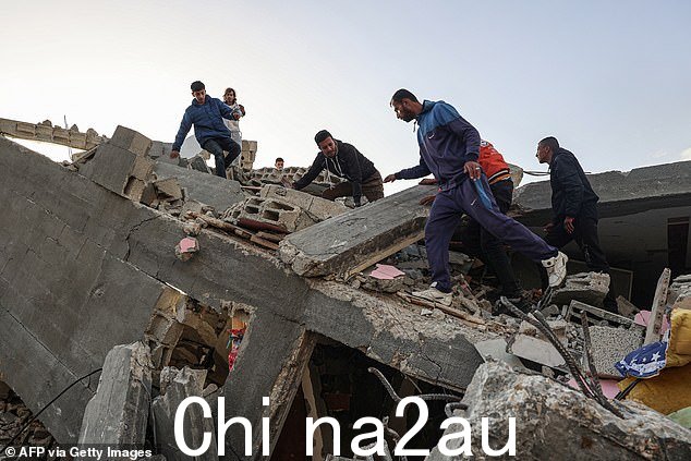 巴勒斯坦男子在 3 月 3 日以色列连夜空袭加沙地带南部拉法的一座房屋废墟中寻找可抢救的物品