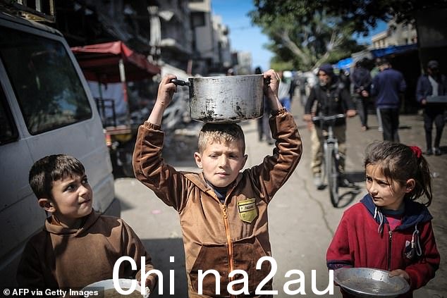 孩子们携带厨房用具走向加沙的食品分发点