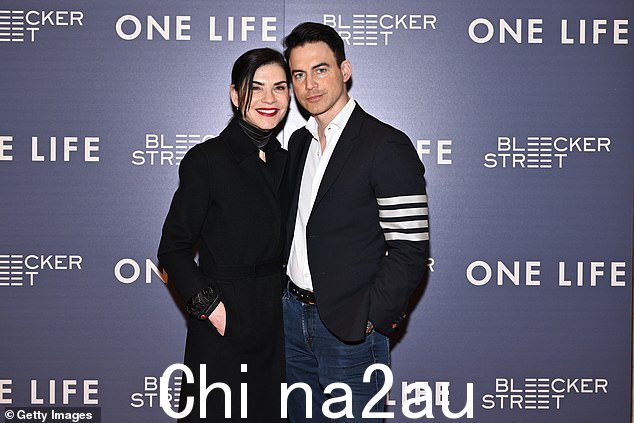 她的丈夫选择了一件白色正装衬衫,里面穿着一件黑色外套,袖子上有灰色条纹。