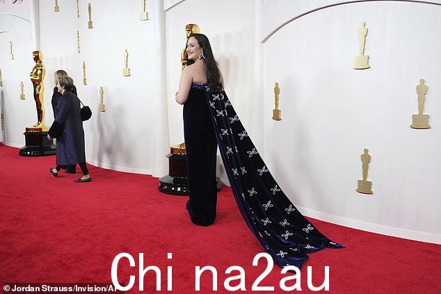 她留着乌黑的波浪卷发,化着烟熏眼妆,涂着浆果唇膏