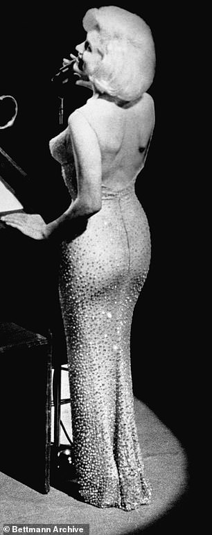 身着裙子的玛丽莲,这是根据鲍勃·麦基 (Bob Mackie) 为服装设计师让·路易斯 (Jean-Louis) 绘制的草图而设计的。照片摄于 1962 年 5 月 19 日,在纽约举行的 45 岁生日派对上,在舞台上为总统先生唱生日快乐歌