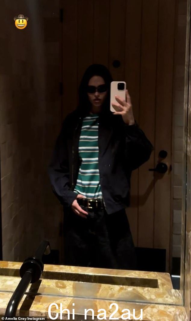 Amelia 将一件绿白条纹衬衫塞进深色裤子