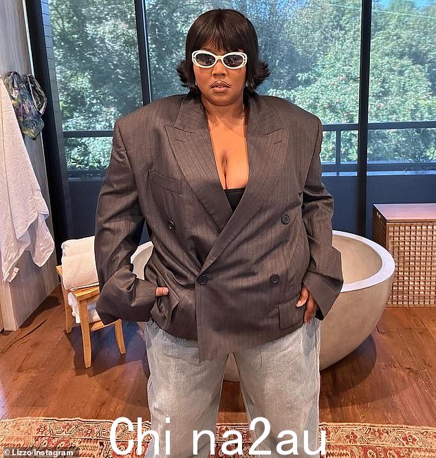 Lizzo,原名 Melissa Viviane Jefferson,也穿了一条宽松的蓝色牛仔裤,搭配白色鞋子