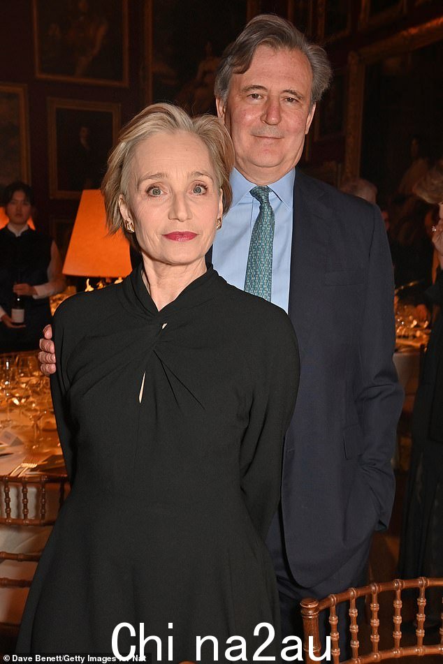 Dame Kristin Scott Thomas 和朋友 John Micklethwait 分别穿着长袖黑色连衣裙和灰色西装,看起来很迷人
