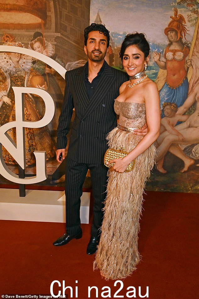 罗宾·阿罗拉 (Robin Arora) 穿着黑色细条纹西装看起来很帅气,而妻子埃莎·阿罗拉 (Esha Arora) 穿着金色羽毛的衣服看起来很漂亮