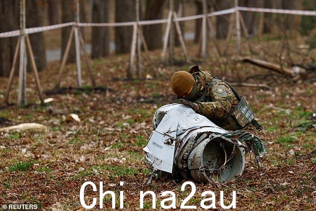 3 月 24 日,一名警察在基辅的一个公园检查在导弹袭击中拦截的俄罗斯 Kh-55 巡航导弹的一部分