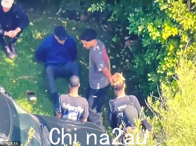 照片显示至少有两名男子,据报道是 King 和 Justin Combs,在洛杉矶突袭期间被戴上手铐