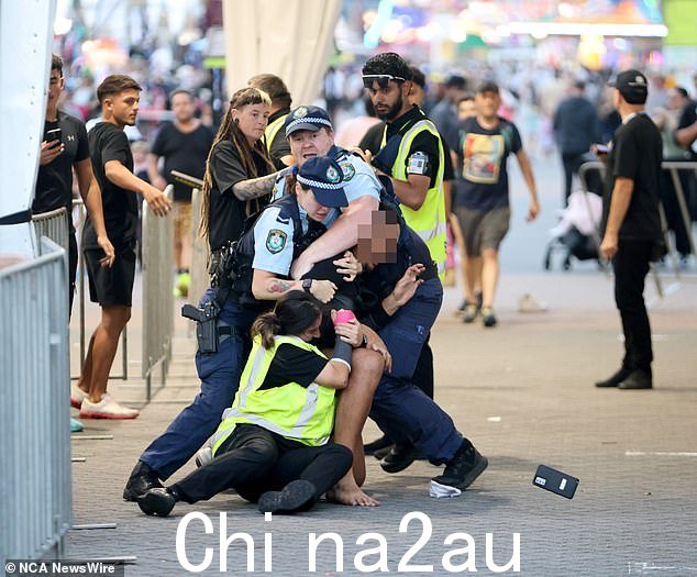 令人震惊的照片捕捉到一名年轻人在悉尼皇家复活节秀门口被警察和保安摔倒在地的那一刻