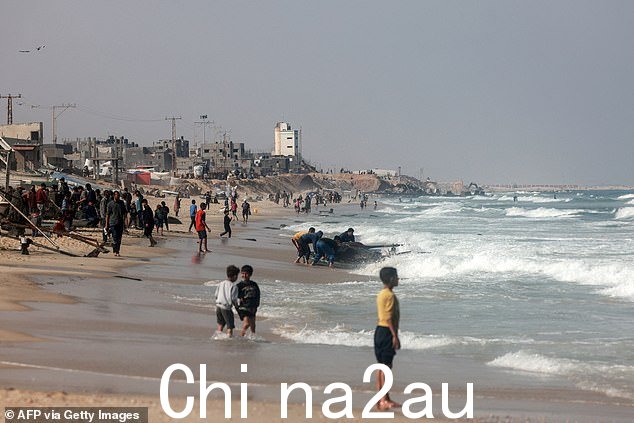 2024 年 3 月 30 日,巴勒斯坦人聚集在加沙地带南部拉法流离失所者临时营地附近的海滩上