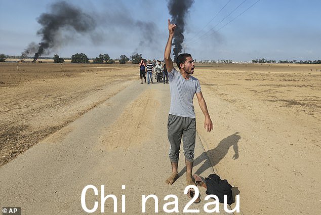 10 月 7 日,Eslaiah 拍摄的照片中,巴勒斯坦人离开以色列 Kfar Azza 基布兹,靠近加沙地带的围栏